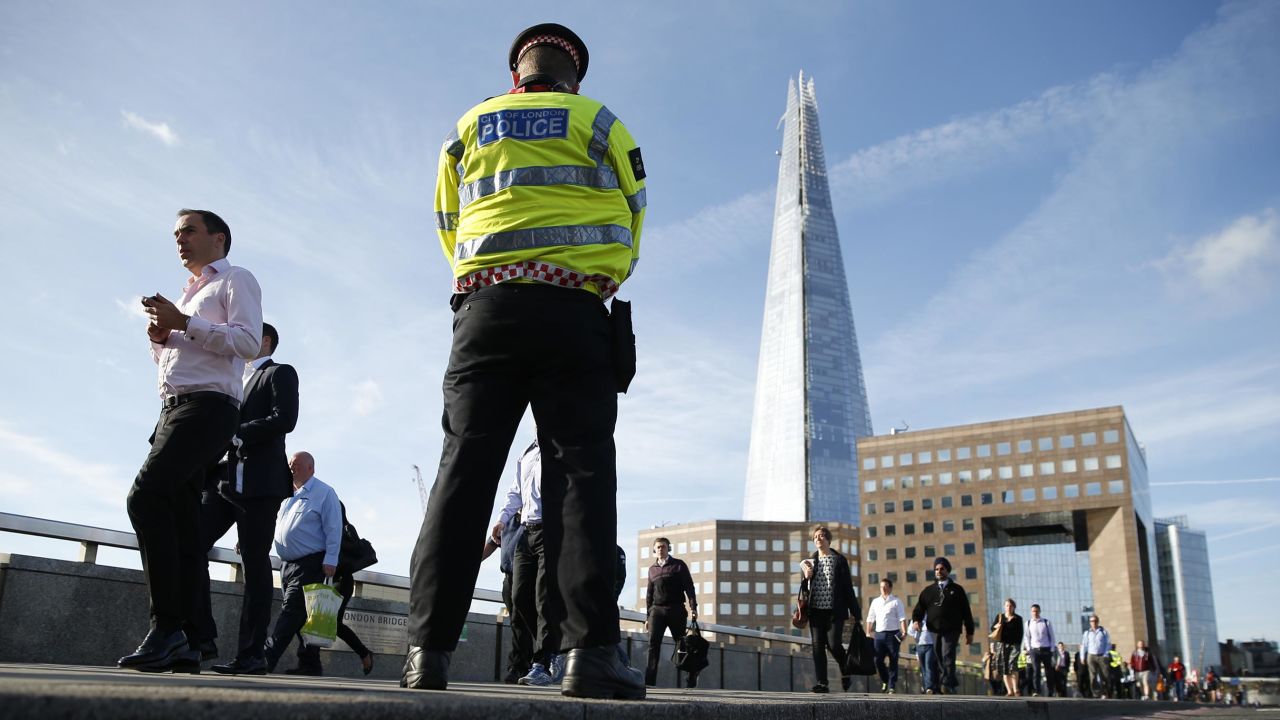 Commuters walk past a police officer on London Bridge in London, Monday, June 5. 