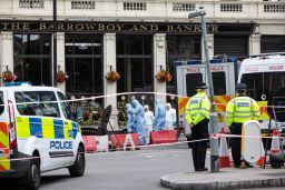 Investigators work the scene along Borough High Street on Monday.