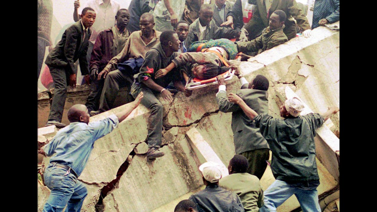 Within minutes of each other, bombs exploded outside the US embassies in Nairobi, Kenya, and Dar es Salaam, Tanzania, on August 7, 1998. In this photo of the aftermath of the Nairobi attack, rescue workers lift Susan Francisca Murianki, a US embassy worker, over the rubble of a collapsed building. The terror group al Qaeda claimed responsibility for the bombings, which left 224 dead and more than 5,000 wounded.