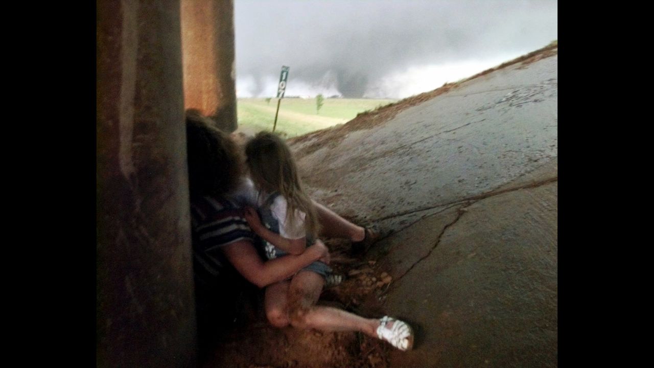 On May 3, 1999, 74 tornadoes touched down across Kansas and Oklahoma, killing 46 people and causing almost $1.5 billion in damage. The strongest tornado to form was an F-5 that ripped through Oklahoma City and its suburbs for nearly an hour and a half. Here, Tammy Holmgren and her daughters seek shelter beneath a roadway as a tornado approaches in the distance. Holmgren and her family were unharmed.