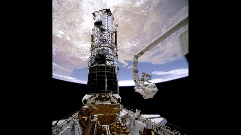Astronaut F. Story Musgrave is hoisted to the top of the <a href="index.php?page=&url=https%3A%2F%2Fwww.nasa.gov%2Fmission_pages%2Fhubble%2Fmain%2Findex.html" target="_blank" target="_blank">Hubble Space Telescope</a> to install protective covers, wrapping up five days of spacewalks to repair and service the telescope in December 1993. Musgrave's handiwork has paid off for humankind; during more than a quarter-century in operation, the Hubble has beamed more than 1 million observations of our universe back to Earth.
