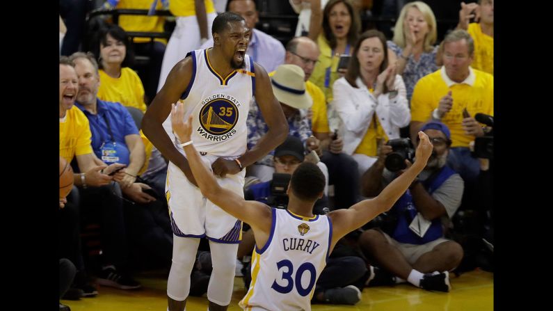 Golden State's Kevin Durant and Stephen Curry celebrate during Game 2 of the <a href="index.php?page=&url=http%3A%2F%2Fwww.cnn.com%2F2017%2F06%2F02%2Fsport%2Fgallery%2Fnba-finals%2Findex.html" target="_blank">NBA Finals</a> on Sunday, June 4. Golden State defeated Cleveland 132-113 to take a 2-0 lead in the best-of-seven series. The Warriors are a perfect 14-0 during this year's playoffs.