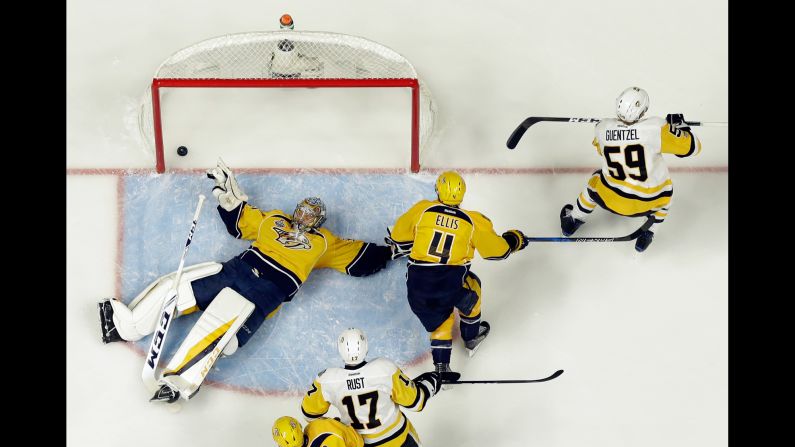 Pittsburgh forward Jake Guentzel, right, skates away after slipping the puck under Nashville goalie Pekka Rinne during Game 3 of the NHL's Stanley Cup Final on Saturday, June 3. The early goal gave Pittsburgh a 1-0 lead, but Nashville rallied for a 5-1 victory. 