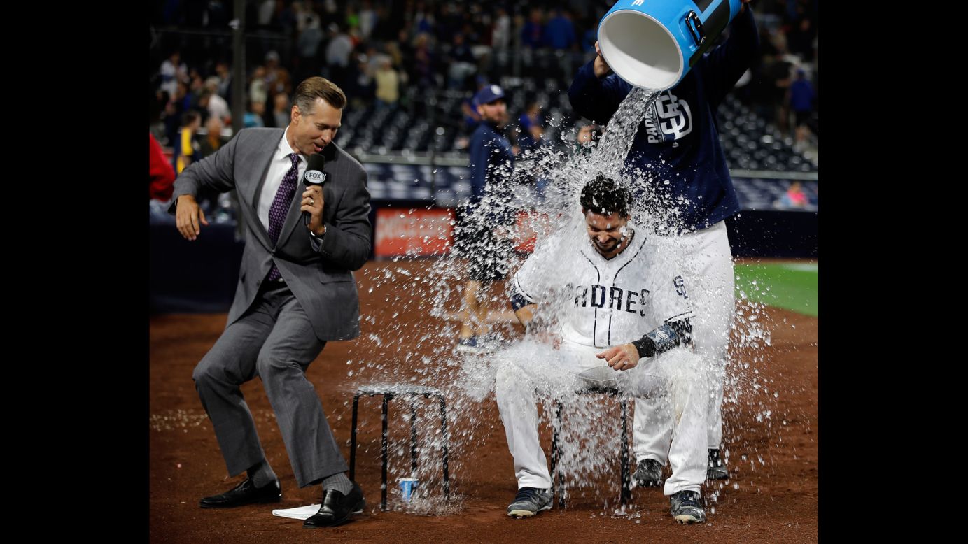 San Diego's Austin Hedges gets drenched by teammate Ryan Buchter during a postgame interview on Tuesday, May 30. Hedges had 4 RBIs in a 6-2 victory over the Chicago Cubs.