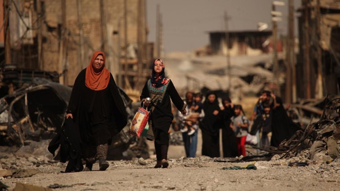 Iraqi civilians escape the fierce battle raging in the Zinjili neighborhood in western Mosul on June 4, 2017. As these women passed by Iraqi security forces, the woman in the orange hijab screamed, "Where were you for the last three years?"