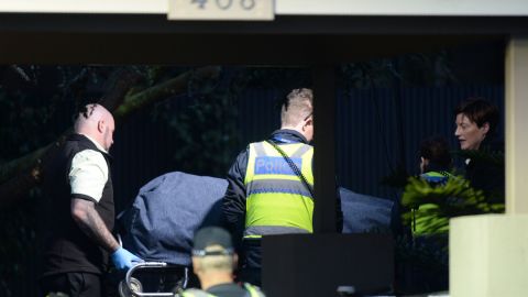Police officers help the coroner remove a body at the scene on June 6.