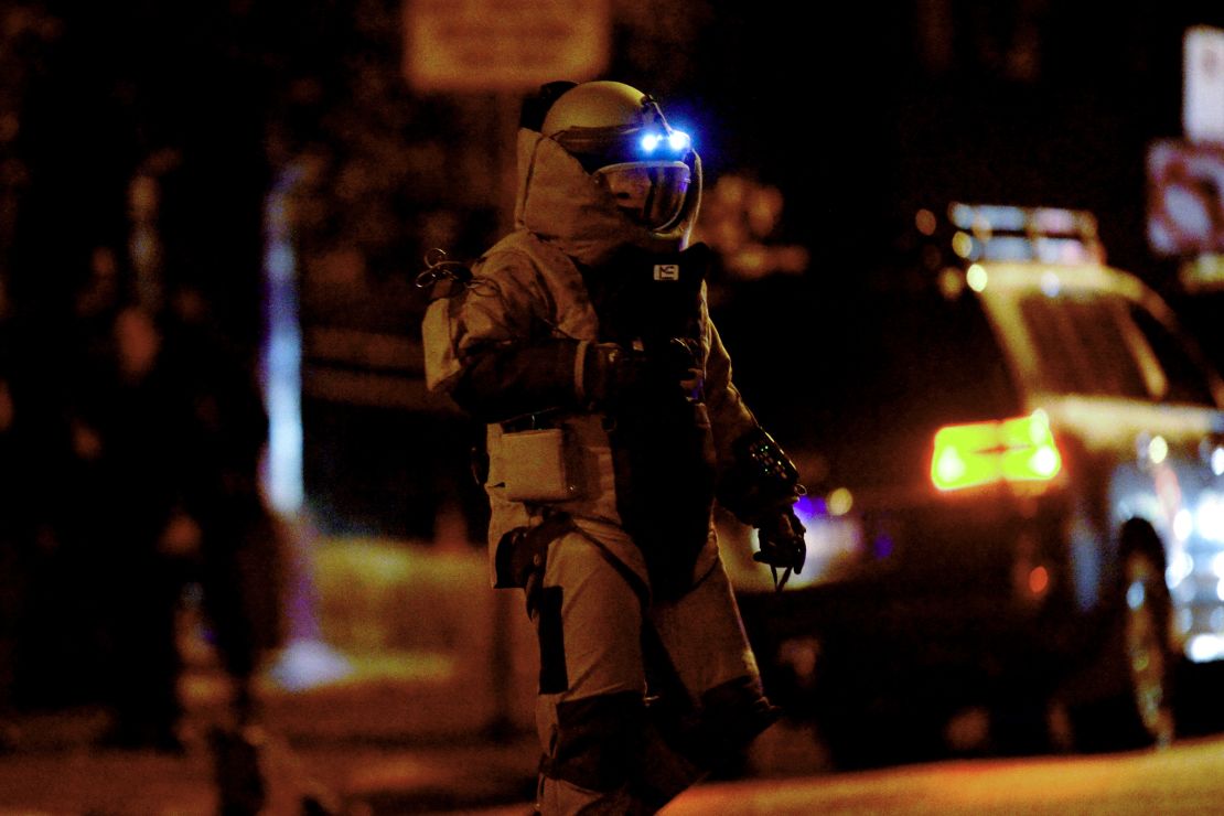 A bomb squad member exits a residential building in Brighton on June 5.