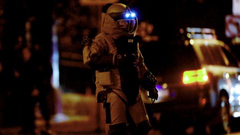A bomb squad member exits a residential building in Brighton on June 5.