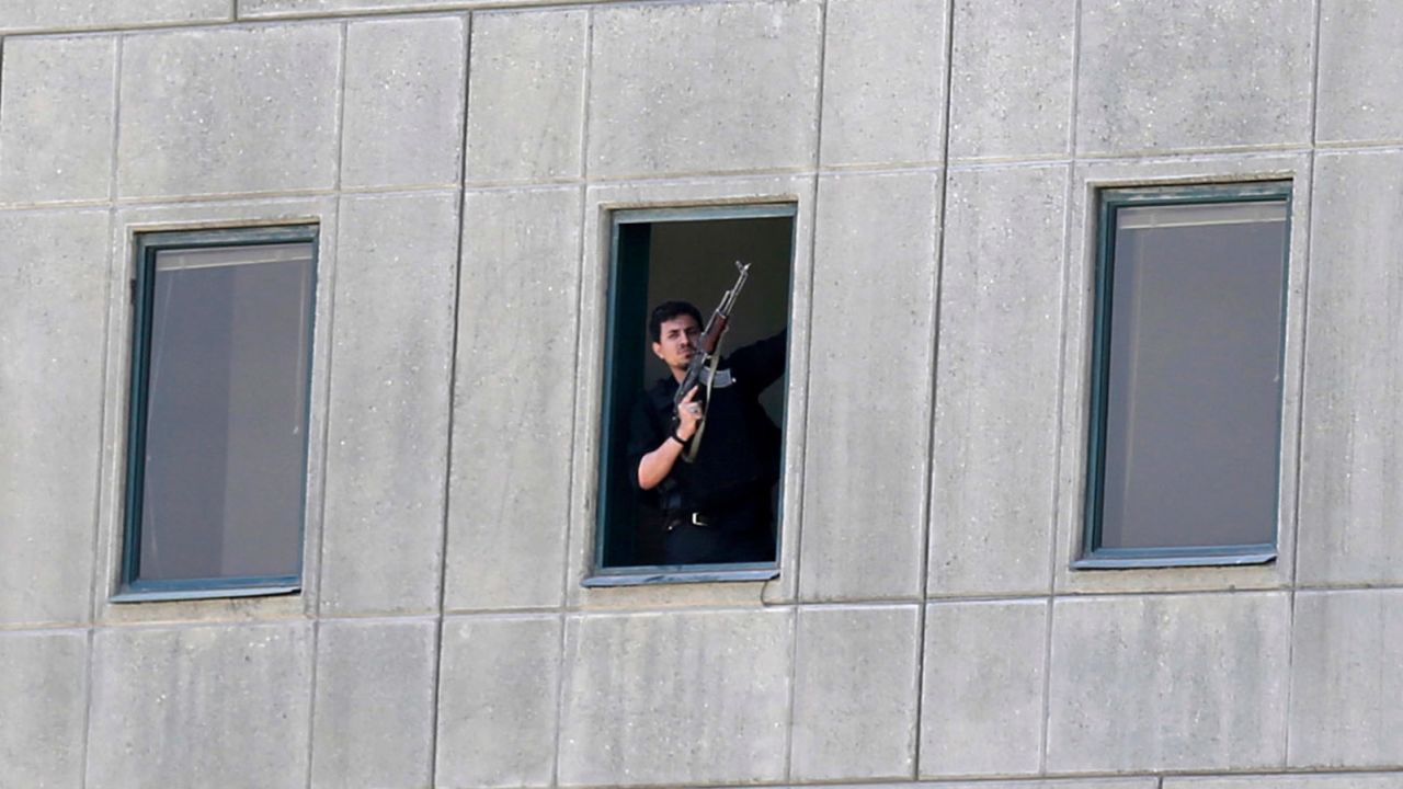 An armed man stands in a window of the Iranian parliament building on June 7.