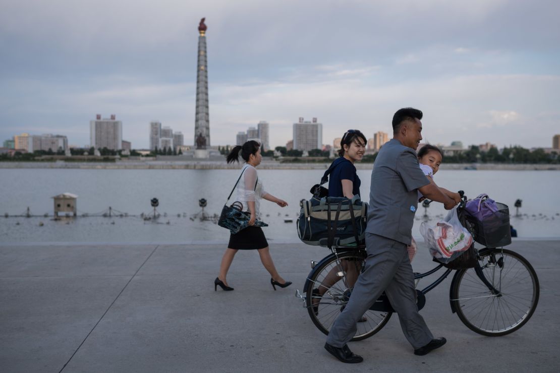 North Koreans walk past the Juche Tower in Pyongyang. The country has criticized Trump's decision to withdraw from the Paris climate agreement.