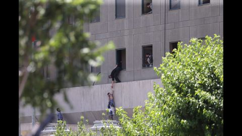 Police help civilians escape the Iranian parliament building Wednesday during twin attacks.