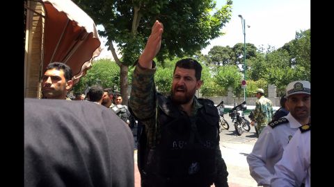A policeman gestures while officials secure the streets of Tehran as a siege unfolds Wednesday at the parliament building.  
