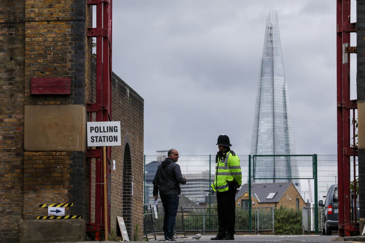 A voter greets a police officer at a polling station in London.