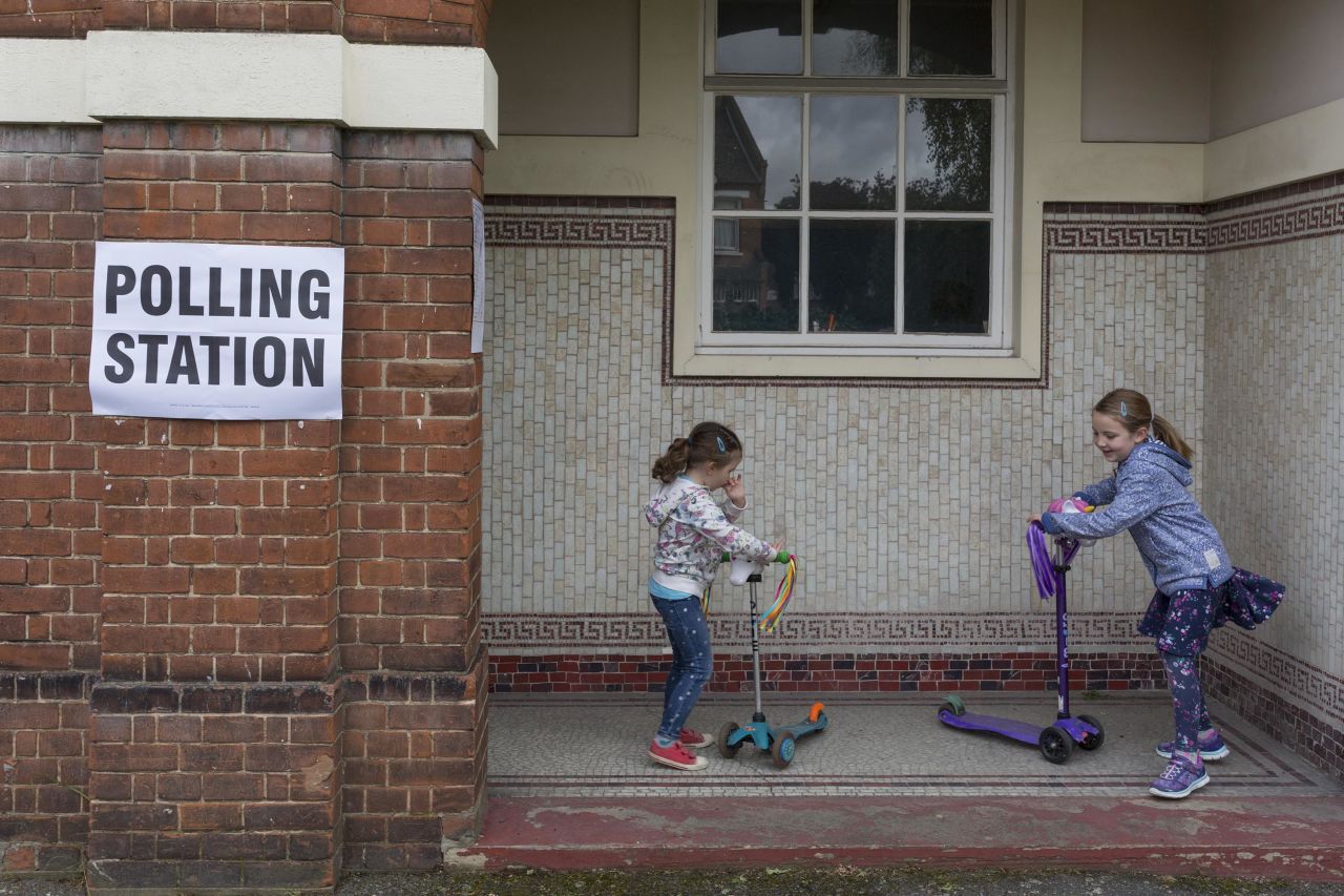 Children play on scooters outside a polling station in London.