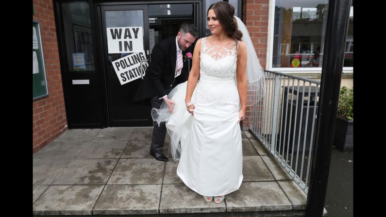 Sorcha Eastwood, an Alliance Party candidate in Northern Ireland, stands outside a polling station in Lisburn after casting her vote. She and her husband, Dale Shirlow, were married earlier in the day.