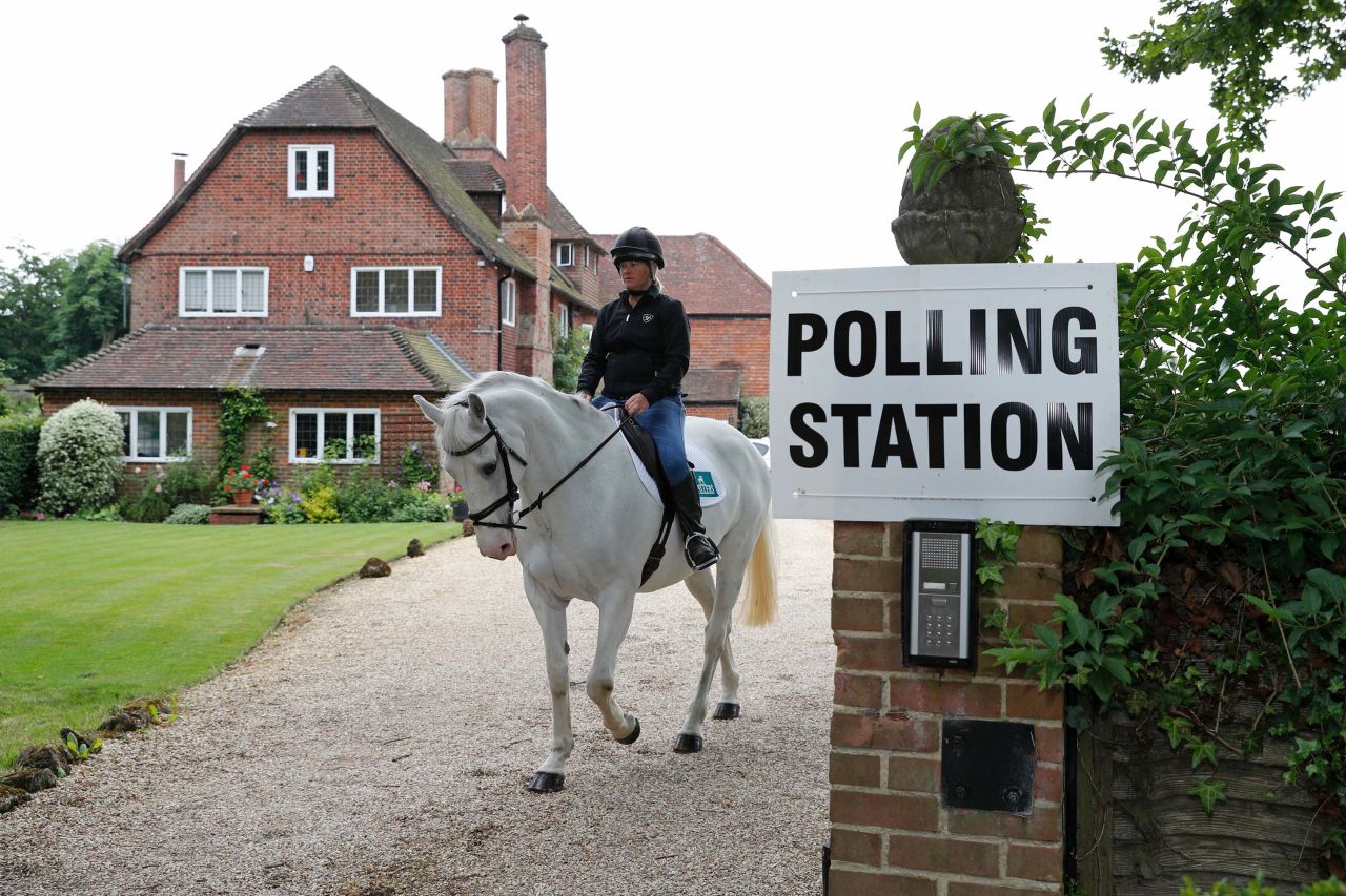 Sophie Allison rides her horse out of a polling station set up at a private residence near Reading, England.