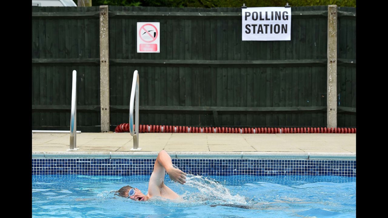 A swimmer does laps at a public pool where a polling station was set up in Arundel, England.