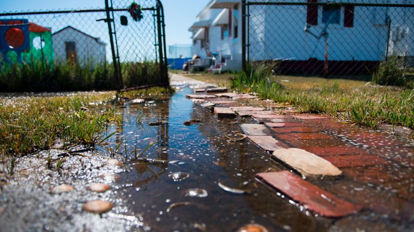 Sea water collects on the front walk way of a home in Tangier, Virginia, May 15, 2017, where climate change and rising sea levels threaten the inhabitants of the slowly sinking island.
Now measuring 1.2 square miles, Tangier Island has lost two-thirds of its landmass since 1850. If nothing is done to stop the erosion, it may disappear completely in the next 40 years. / AFP PHOTO / JIM WATSON        (Photo credit should read JIM WATSON/AFP/Getty Images)
