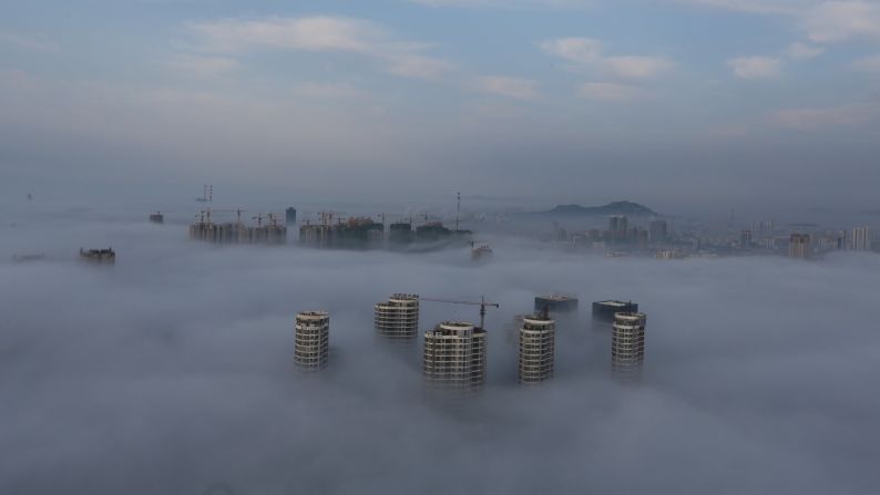 Buildings and construction sites are seen among fog in Rizhao, China, on Friday, June 2.