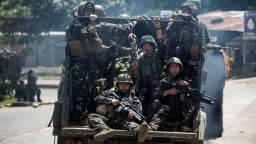 Soldiers aboard their vehicles maneuver through a street in Marawi on Saturday.