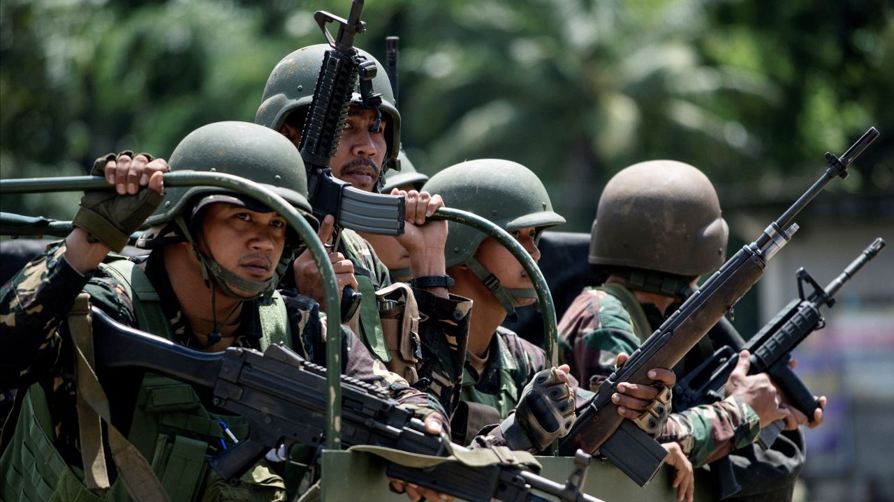 Soldiers aboard their vehicles maneuver through a street in Marawi, on the southern island of Mindanao on June 10, 2017.