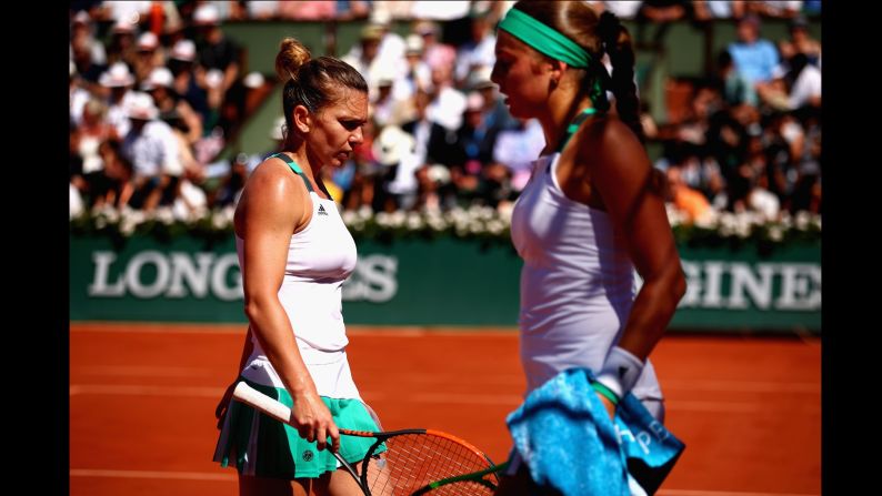 Simona Halep and Jelena Ostapenko pass each other to change sides during the women's singles final match on June 10.