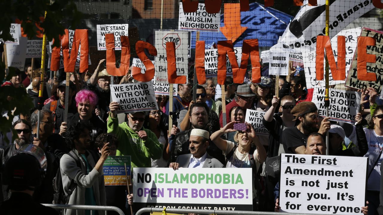 Counterprotesters hold a signs across the street from an anti-Islamic law rally in Seattle.