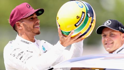 Lewis Hamilton was presented with one of Ayrton Senna's race helmets after equaling the Brazilian's tally of 65 career poles. 
