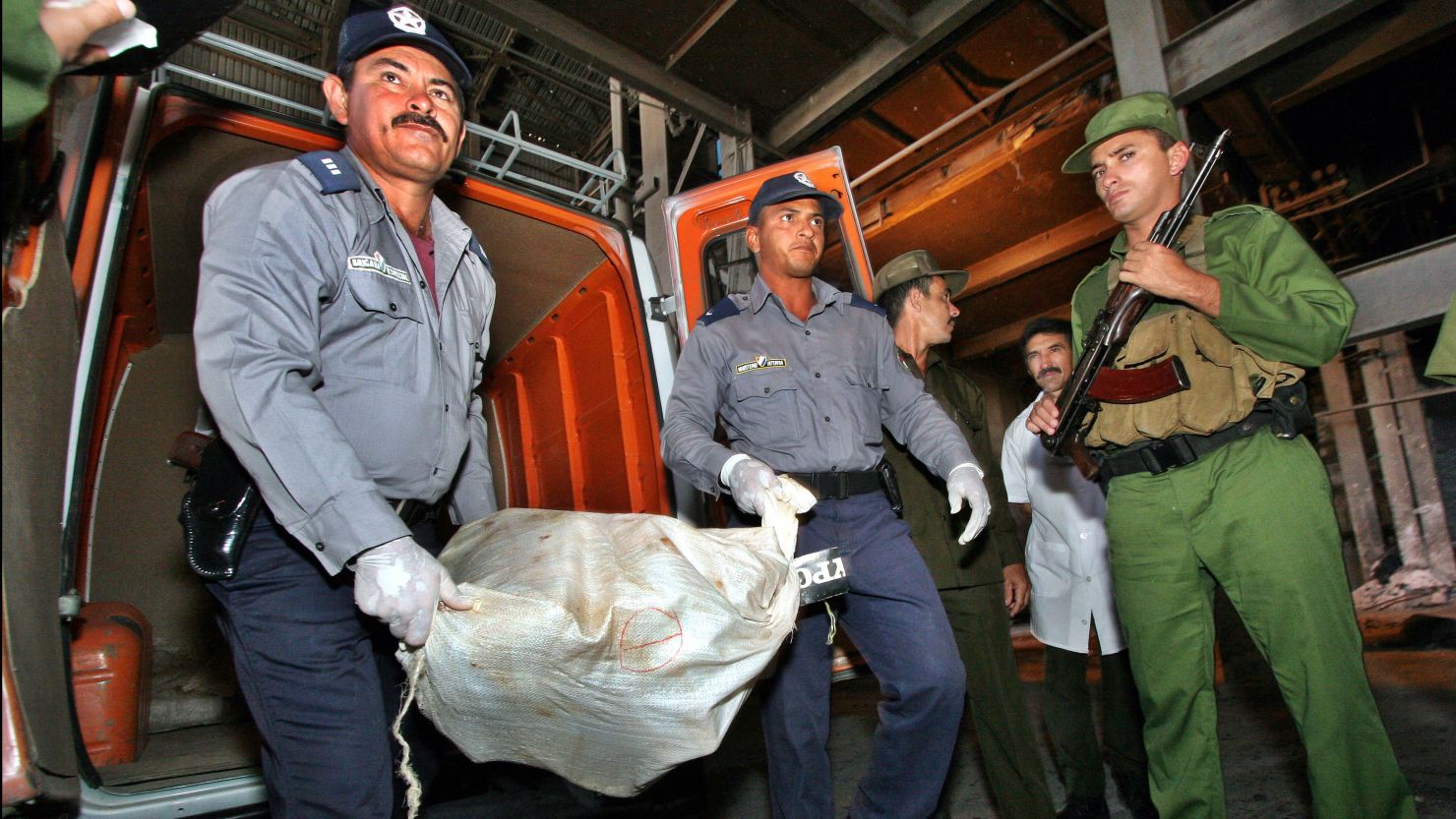 Cuban police officers and Coast guards unload 25 sacks of marijuana on February 22, 2005 in Las Tunas, Eastern Cuba.
