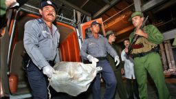 Cuban police officers and Coast guards unload 25 sacks of marijuana on February 22, 2005 in Las Tunas Eastern Cuba. The drug seized from three Jamaicans in a speed boat were burned  in a boiling-hot cauldron at a steel factory during a tour for the foreign media.
