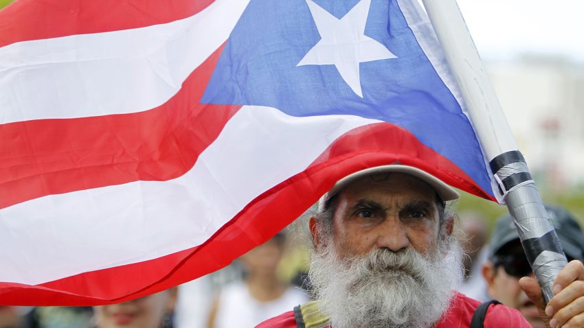 A man carries a Puerto Rican flag during a protest against the referendum for Puerto Rico political status in San Juan, on June 11, 2017.
To become a true US state, to choose independence or to maintain the status quo: Puerto Ricans went to the polls to consider their political future in a non-binding referendum many have vowed to boycott. / AFP PHOTO / Ricardo ARDUENGO        (Photo credit should read RICARDO ARDUENGO/AFP/Getty Images)