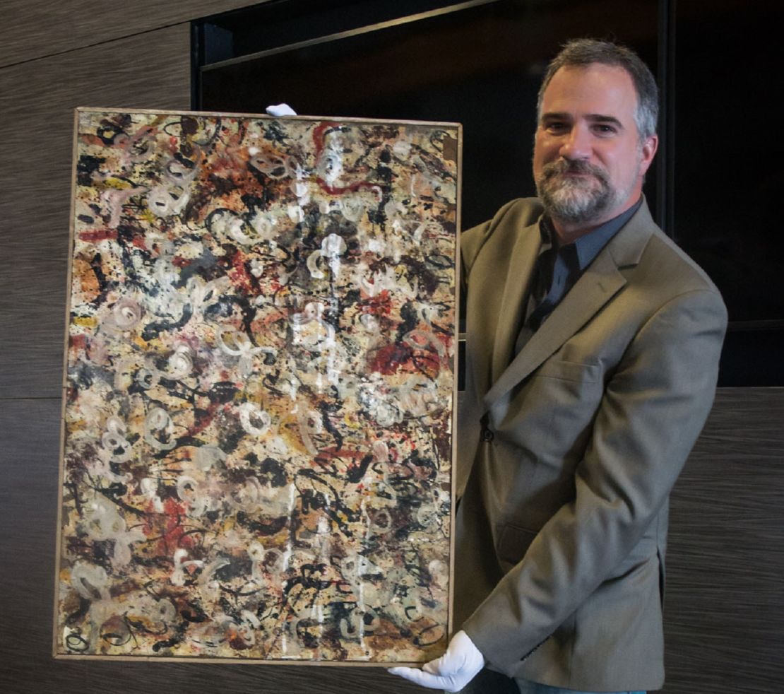 Auctioneer Josh Levine poses with the untitled Jackson Pollock painting.