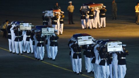 Philippine marines honour guards carry the caskets containing the bodies of their colleagues killed last June 9 in Marawi, shortly after arriving at a military base in Manila on June 11.