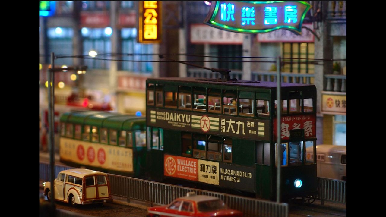 A close-up shot depicts a tram running past the pier on Hong Kong's Connaught Road.