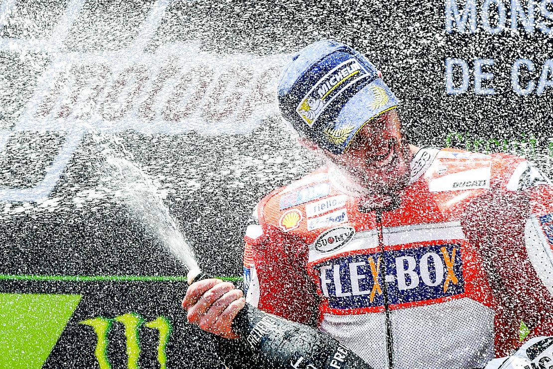 Andrea Dovizioso celebrates on the podium after winning the Catalunya MotoGP.