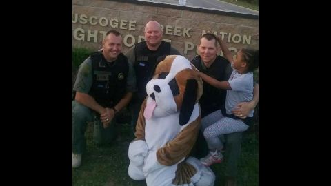 Three officers of Creek Nation Lighthorse Police host 7 year old Rosalyn Baldwin.