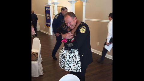 Rosalyn Baldwin, 7, hugs Sheriff Jason Ard of Livingston Parish, LA.