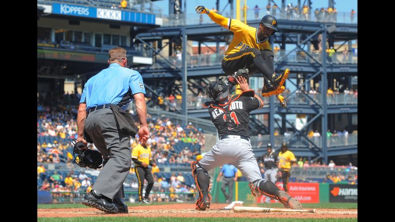 Pittsburgh's Andrew McCutcheon tries to jump over Miami catcher J.T. Realmuto, but he is tagged out at home during a Major League Baseball game in Pittsburgh on Sunday, June 11.