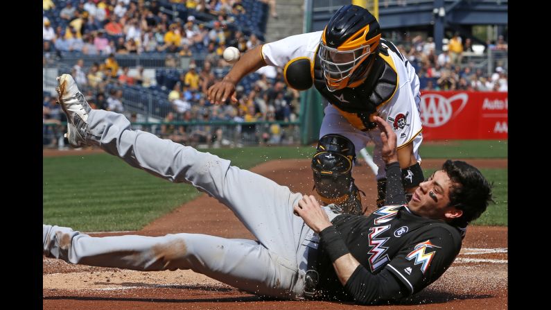 The ball gets away from Pittsburgh catcher Elias Diaz as Miami's Christian Yelich scores a run on Saturday, June 10.