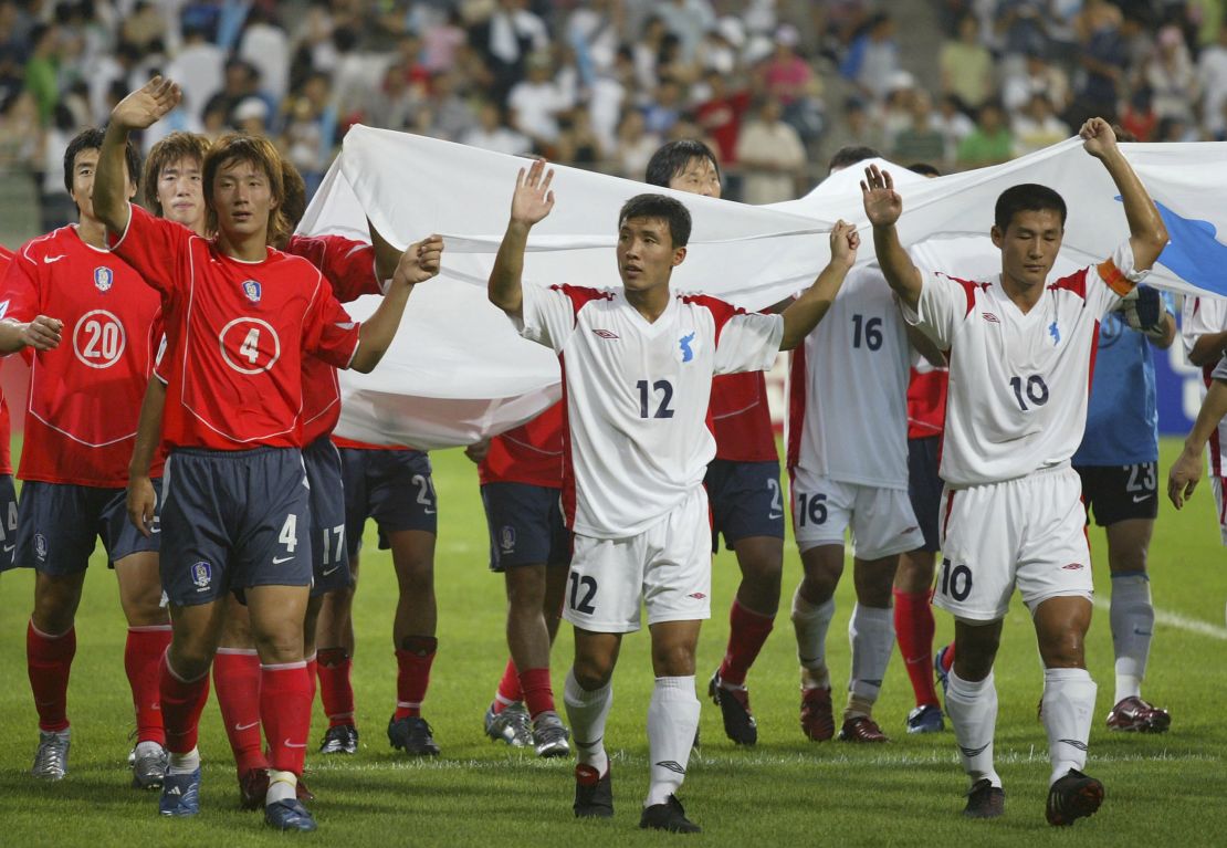 Soccer players holds unification flags after a friendly match between South and North Korea on August 14, 2005 in Seoul