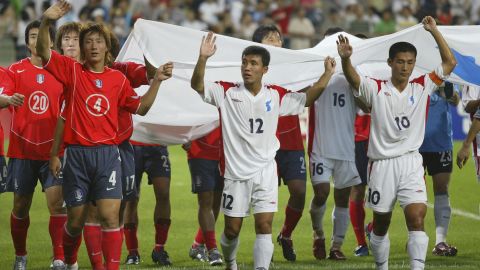 Soccer players holds unification flags after a friendly match between South and North Korea on August 14, 2005 in Seoul