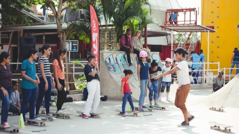 During a workshop, Verghese teaches kids how to skateboard.