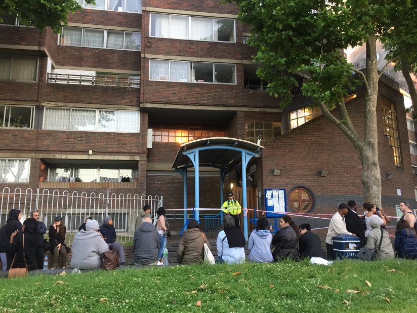 Residents from nearby Barandon Walk wait outside their building. The building was evacuated around 2 a.m. Police told residents that heat emanating from the fire could affect the structure of their building.