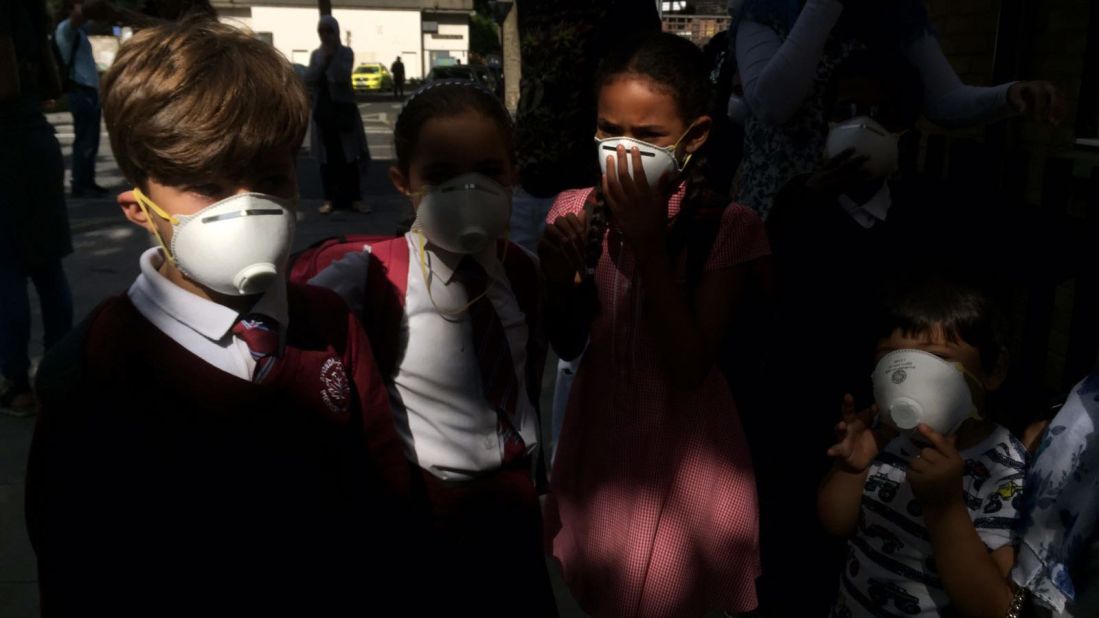 Children wear masks that were distributed near the site of the fire.