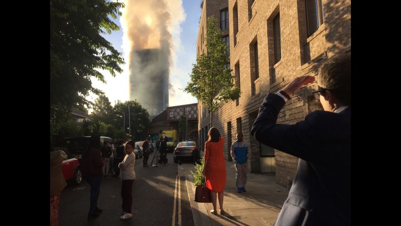 People watch as smoke rises from the tower.