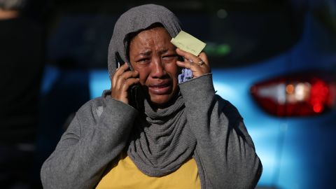 A woman cries as she tries to locate a missing relative.