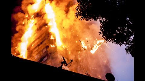 Burning debris falls from Grenfell Tower as a massive fire engulfs the London apartment building early on June 14, 2017. Seventy-two people are confirmed to have died in the fire.