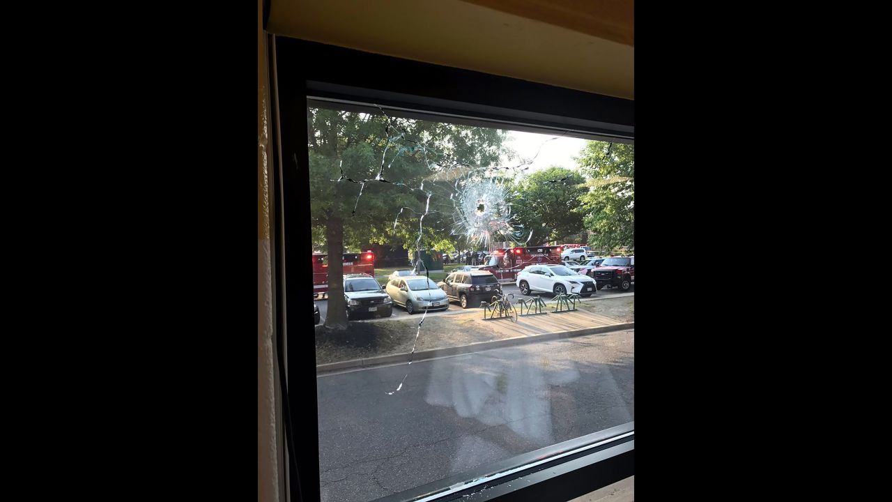 A bullet hole is visible in the window pane of a YMCA near the field in Alexandria.