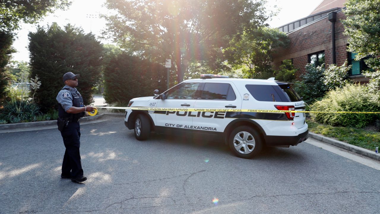 An Alexandria police officer tapes off an area after the shooting.