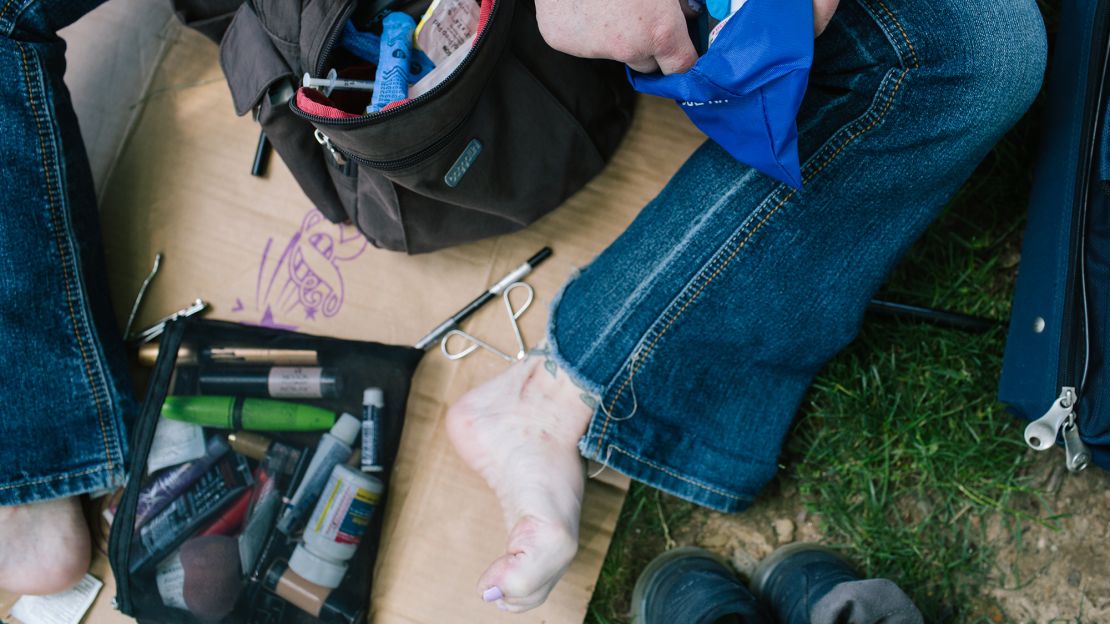 A woman opens an opioid overdose rescue kit in McPherson Square Park in Philadelphia.